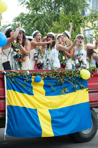 svensk flagga med studenter på lastbil